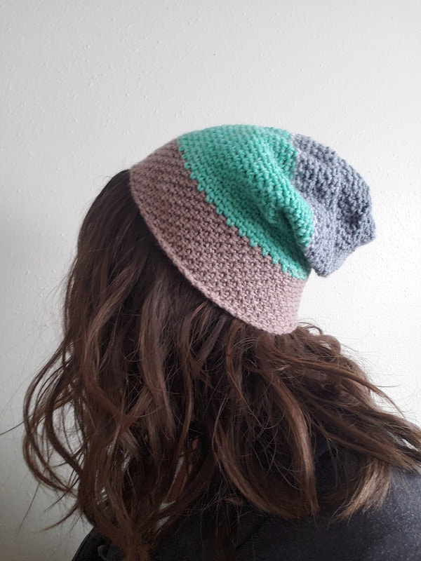 A woman wearing a brown, green, and gray crochet hat
